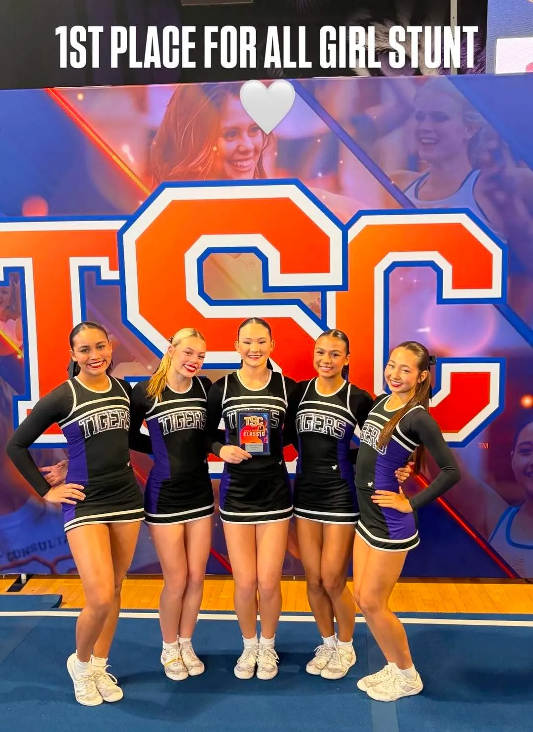 Five Millennium Tigers cheerleaders posing with their first-place plaque after the All Girl Stunt event at the TSC competition